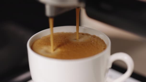 ホットコーヒーでカップを満たすコーヒーマシン。コーヒーマシンでコーヒーをカップにすると、自動コーヒーメーカーのエスプレッソコーヒーが出てきます。朝食用飲料 — ストック動画