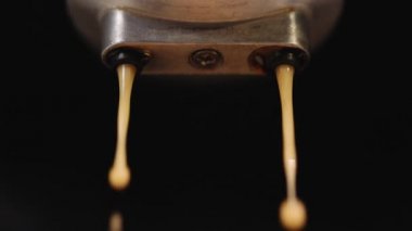 Close up Slow Motion of Espresso Pouring from Coffee Machine. Drinking roasted black coffee. Making espresso Flowing fresh ground coffee. Pouring coffee stream from professional machine in cup