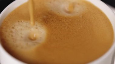 Automatic coffee machine with coffee capsules or pods pouring double espresso drink. Drinking roasted black coffee. Pouring coffee stream from machine in cup