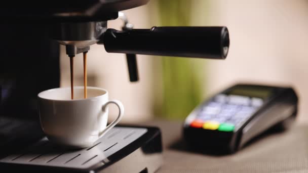 Proses membuat minuman vegan bebas laktosa di kedai kopi. Mesin Espresso membuat kopi segar. Menuang aliran kopi dari mesin dalam cangkir. Coffeeshop dengan terminal mesin kartu kredit NFC — Stok Video