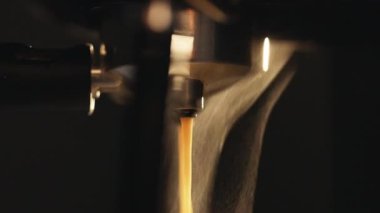 Makineden kahve dökmek arka ışık buharı aydınlatır. Sıcak Espresso yapıyorum. Taze kahve akıyor. Sabahları kavrulmuş sade kahve içmek.