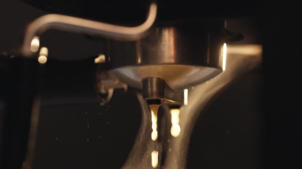 Automatic coffee machine pouring espresso drink. Making of strong coffee in a coffee machine, the back light illuminates the steam. Flowing fresh ground coffee. Drinking roasted black coffee — Vídeo de stock