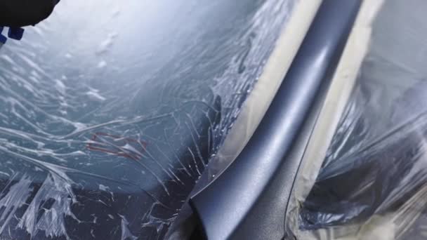 자동차화 가는 특별 부스에 있는 자동차의 부품에 검은 페인트를 뿌리고 있다. 자동차 봉사 부에서 자동차 부품에 그림을 그리는 모습. — 비디오