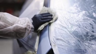 Araba boyacısı arabayı boyama ve vücut parçaları için hazırlıyor.