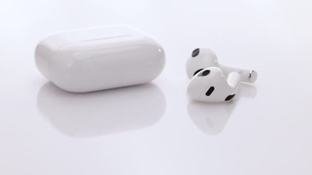 Bluetooth навушники ізольовані на білому тлі. Гаджети та електронні пристрої. Бездротові навушники з технологією шумозаглушення. Бездротові навушники з зарядним чохлом . — стокове відео