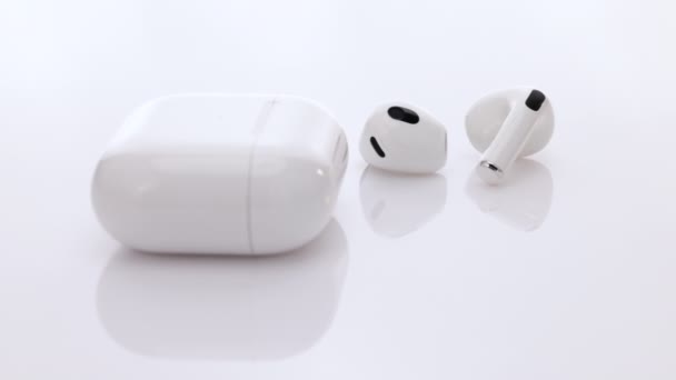 Auricolare senza fili con tecnologia di cancellazione del rumore. Cuffie Bluetooth isolate su sfondo bianco. Cuffie wireless con custodia di ricarica. Gadget e dispositivi elettronici — Video Stock