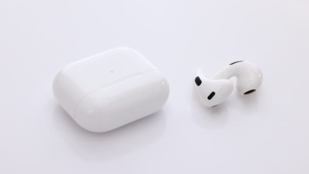 Cuffie Bluetooth isolate su sfondo bianco. Gadget e dispositivi elettronici. Cuffie wireless con custodia di ricarica. Auricolare senza fili con tecnologia di cancellazione del rumore — Video Stock