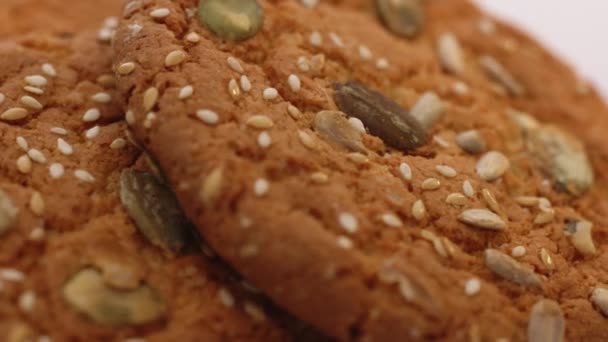 El trigo cae en las galletas dietéticas. Come galletas de avena. El concepto de hacer galletas fritas. Delicioso bocadillo sabroso de galletas marrones aisladas rotan sobre fondo blanco. — Vídeos de Stock