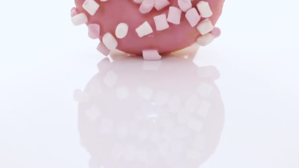 Pink glazed marshmallow donut. Bright and colorful sprinkled donut on a white background. Assortment of donuts of different flavors — Stock Video