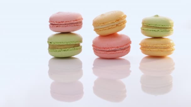 Macarons Kuchen in verschiedenen Farben auf weißem Hintergrund. Kulinarisches und Kochkonzept. Leckere bunte Makronen — Stockvideo