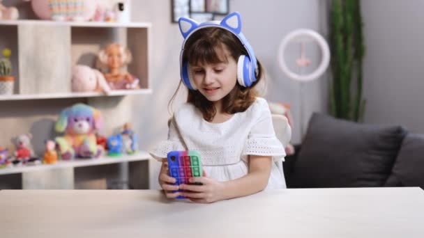 Happy hipster teen dívka nosit sluchátka poslouchat dj pop hudbu v obývacím pokoji. Usmívající se gen z teenager modelka tanec sám při pohledu na kameru. — Stock video