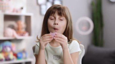 Genç ve güzel esmer kız gülümser, bir şey düşünür, elindeki küçük makarna kurabiyesine bakar ve ısırır.