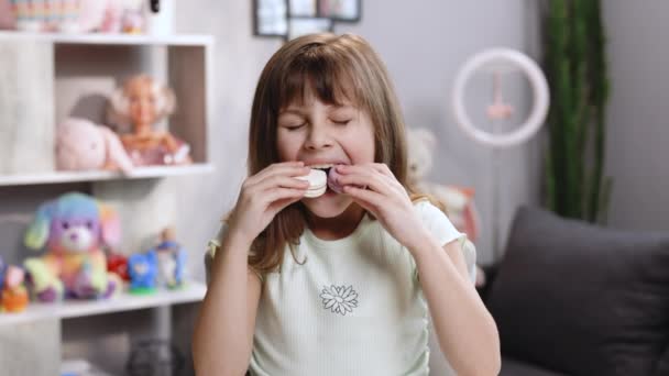 Krásná povedená školačka chce sníst dva makaróny najednou, široce otevře pusu. Dezert, výborný. Chutné sladké barvy macaron. — Stock video