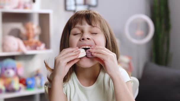 Hilariante menina da escola quer comer dois macarons ao mesmo tempo, abre amplamente a boca. Sobremesa, deliciosa. Macaron de cor doce saboroso. Sentindo-se bem, delicioso — Vídeo de Stock