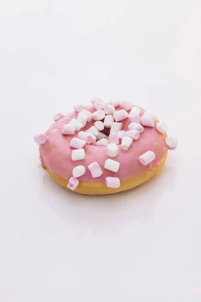 Brilhante e colorido donut polvilhado tiro close-up sobre um fundo branco. Sortimento de rosquinhas de sabores diferentes. Rosado vidros e polvilhas donut — Fotografia de Stock