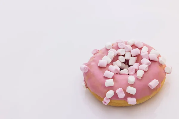 Heldere en kleurrijke donut op een witte achtergrond. Assortiment van donuts van verschillende smaken. Roze geglazuurde marshmallow donut — Stockfoto