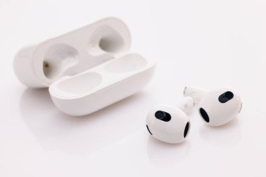 Bluetooth kulaklıklar beyaz arka planda izole edilmiş. Aletler ve elektronik cihazlar. Ses engelleyici teknolojili kablosuz kulaklık. Şarj çantalı kablosuz kulaklık..