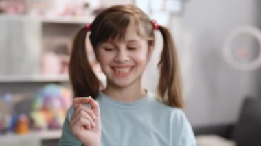 Süt dişli küçük kız. Düşen dişini elinde tutan mutlu kız. Diş hekimliği veya geçici diş sağlığı konsepti