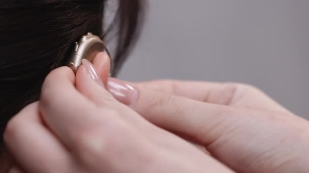 Donna con sintomo di perdita dell'udito. L'infermiera indossa un apparecchio acustico. Donna matura tesa con le dita vicino all'orecchio. Donna con apparecchio acustico. — Video Stock