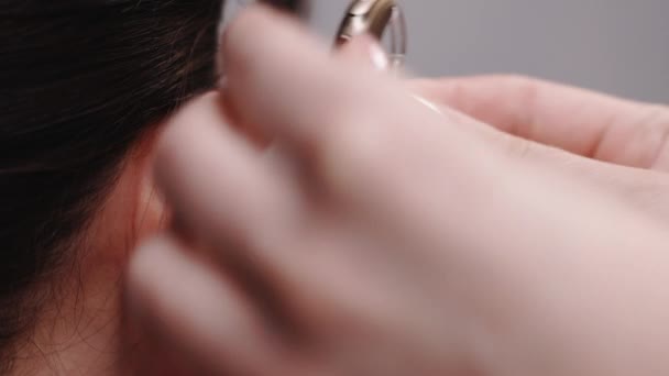 Detailní záběr na ucho s naslouchátkem, mladá hluchá žena přizpůsobující se prostředí. Žena s příznakem ztráty sluchu. Žena sestra nosí naslouchátko. — Stock video