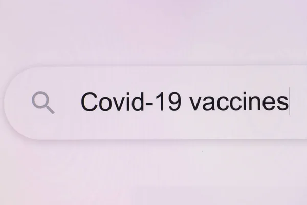 Escribir la palabra COVID 19 vacunas en el navegador y hacer clic en el botón de búsqueda en una pantalla de ordenador pixelada. COVID-19 vacunas - Barra de búsqueda del navegador de Internet escribiendo coronavirus investigación de información —  Fotos de Stock