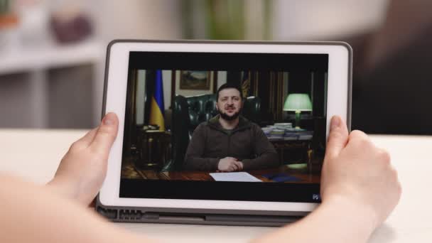 Lviv, Ukraina 7 april 2022: Titta på surfplatta dator Ukraina president Volodymyr Zelensky talar till världen av kriget med Ryssland. Rysk aggression. Hot om krig. — Stockvideo