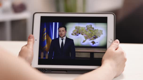 리비우 (Lviv), 우크라이나 2022 년 4 월 7 일: 우크라이나 대통령볼 로디 미르 젤 렌 스키가 우크라이나인에게 연설. 정치가, 배우. 여자들 손에 태블릿 컴퓨터를 쥐고. 우크라이나 전쟁 — 비디오