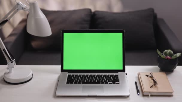 Cuaderno con pantalla verde para la tecnología de croma key, zoom tiro en la mesa en la sala de estar, lugar de trabajo remoto en el hogar. Ordenador portátil con una pantalla verde clave juego de maquetas en la mesa de trabajo en casa — Vídeo de stock