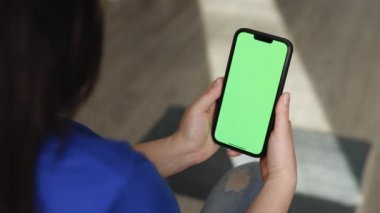 Yeşil ekran krom anahtar arka planında akıllı telefonu tutan tanınmayan bir kadın. Ürününüz için cep telefonu modeli dikey yönelim portre modunda. Kadın elinde boş dijital akıllı telefon