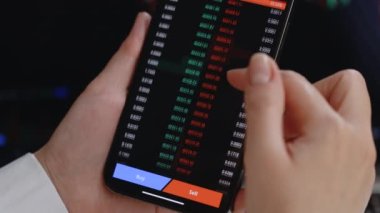 Yatırımcı cep telefonu ekranında Bitcoin, Ethereum ve diğer şifreli para birimi fiyat indeksini kontrol ediyor. Finansal analist çalışıyor. Kripto para birimi gelecekteki fiyat öngörüsü kavramı