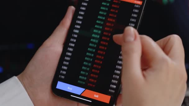 投资者在手机智能手机屏幕上查看比特币、 Ethereum和其他比特币加密货币价格指数。金融分析师在工作加密货币未来价格行为预测概念 — 图库视频影像