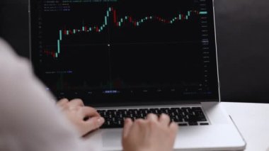 Monitörde çalışan işlemciyi kapat ve ticaret ofisinde internete gir. Kadın komisyoncu fiyatları ve bahisleri takip ediyor. Bir borsa grafiğini analiz eden iş kadını.