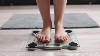 Female On Scales Measure Weight. Fit Girl Legs Step Bathroom Scale. Fitness Diet Woman Feet Standing Weighing Scales. Barefoot Measuring Body Fat Overweight. Dieting Woman Checking BMI Weight Loss.