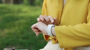 Akıllı bir el ile kadın eli yakın çekim. Akıllı saat uyarısı kontrol ediliyor. Akıllı sekte kaydırma ekranı. Kafkasyalı kız akıllı kaset kullanıyor..