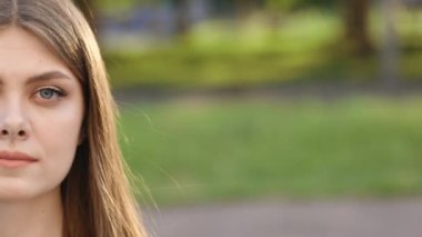 Boş bir kasabada dışarıda dikilirken kameraya bakan üzgün, beyaz bir genç kadın yüzü. Makyajlı güzel bir genç kadının yarım portresi..