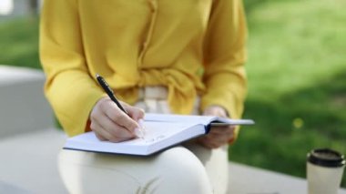 Bir kız dizüstü bilgisayarından notlar alır. Evde ders çalışan genç bir kız bilgisayar başında canlı bir ders izliyor, notlar alıyor, uzaktan eğitim kavramını ön plana çıkarıyor.