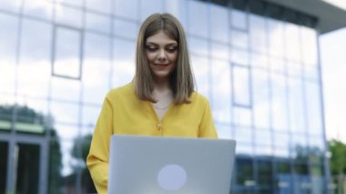 Genç bir kadın şehir parkında bir bankta oturuyor ve dizüstü bilgisayar kullanıyor. Bilgisayarla bilgisayar eğitimi alan Avrupalı iş kadını girişimci bilgisayar kursuna odaklanmış. Serbest çalışma kavramı