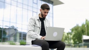 Ofisin yakınında dizüstü bilgisayarla çalışan mutlu Ermeni iş adamı. Beyaz bir erkek yönetici bilgisayarlı uzaktan eğitim kullanıyor, internette geziniyor, sanal toplantı yapıyor, bilgisayarda yazıyor..
