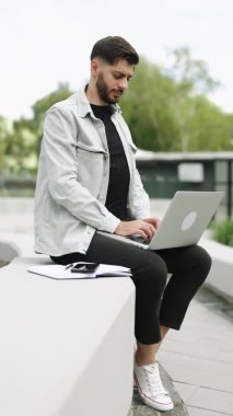 Uzaktan çalışan, internette gezinen sanal toplantı yapan, bilgisayarda yazan beyaz erkek yöneticinin dikey ekranı. Ofisin yanındaki dizüstü bilgisayarda çalışan mutlu Ermeni iş adamı..