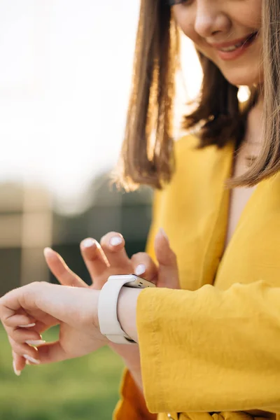 Smart watch. Scrolling display on smartwatch. Checking incoming notification on smart watch. Touch Screen Wearable Technology Smart Band. Caucasian woman using smartwatch digital device in the city.