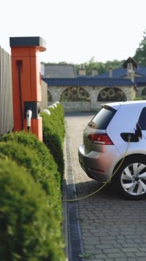 Vertical format video of electric vehicle parking at the charging station. Electric vehicle battery cell recharging. Zero emission vehicle on EV only charging station is parked