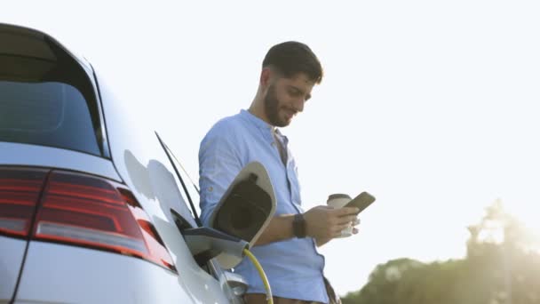 Gorgeous Bearded Caucasian Man Blue Shirt Standing Electric Car Charging — Video Stock