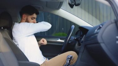 Sakallı adam araba emniyet kemerini eliyle bağlar. Araba kullanmak için güvenlik kurallarına uymak. Araçlarda bir kişinin korunması. Arabanın emniyet kemeriyle vücudunu bağla. Yol güvenliği yönetmeliği kavramı