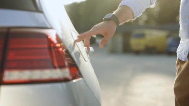 Tanınmayan işadamı elektrik kablosunu elektrikli araca bağlıyor. Erkek el güç bağlantısını EV arabaya yerleştirir ve pilleri şarj eder, aktifleştirmek için akıllı kaset kullanır