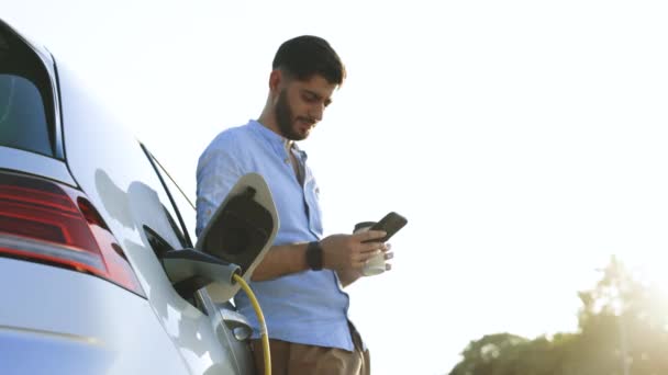 Bearded Caucasian Man Blue Shirt Standing Electric Car Charging Making – stockvideo