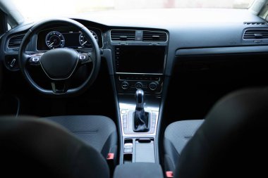 Electric car interior details adjustments. Inside car interior with front seats, driver and passenger, textile, windows, console, gear shift, electric buttons, digital speedometer.