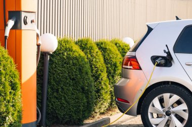 Elektrikli Araç ve Otobüs Şarj Noktaları. Mağaza yakınlarındaki EV, PHEV ve HEV için modern elektrik şarj istasyonu çekimi. Şarj İstasyonu Elektrikli Araç Şarj İstasyonu.