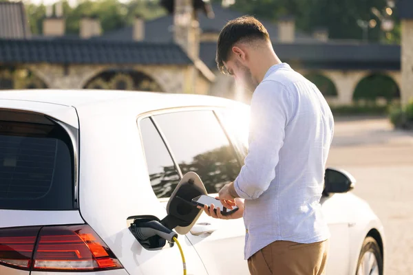 Caucasian Male Unplugging Electric Car Charging Station Man Unplugging Power — Stockfoto