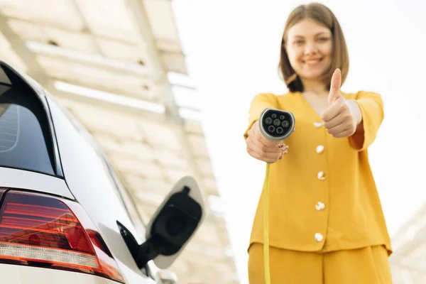 Female Showing Thumbs Holding Power Cable Supply Plugged Electric Car — Stockfoto