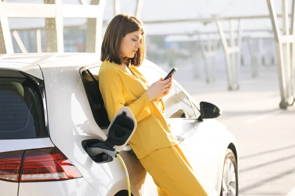 Caucasian Woman Stands Mobile Phone Her Electric Car Waits Vehicle — Stockfoto